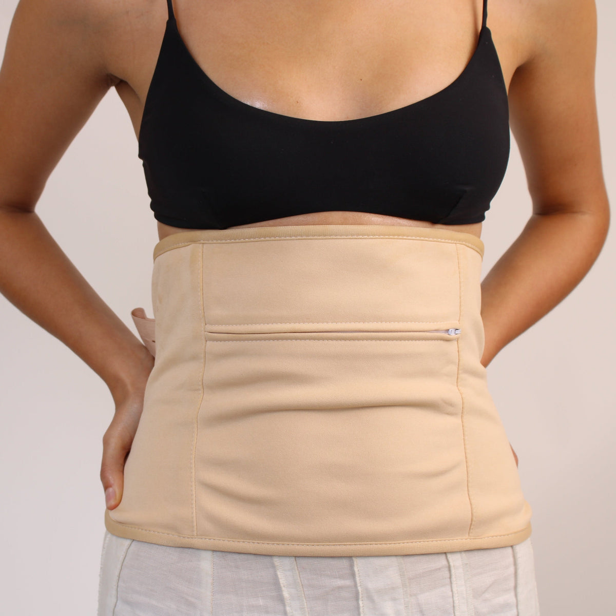 Woman wearing a Castor Oil Body Wrap for Waist and Back, showcasing its comfortable design and organic cotton inner.