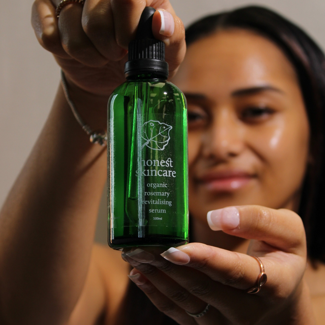 Organic Rosemary Oil for Hair in a green bottle held by a person, showcasing the revitalizing hair serum for stronger hair.