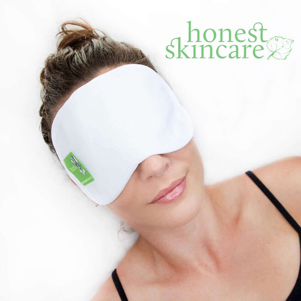 Woman wearing the Honest Skincare castor oil eye treatment wrap for relaxation and skincare benefits.