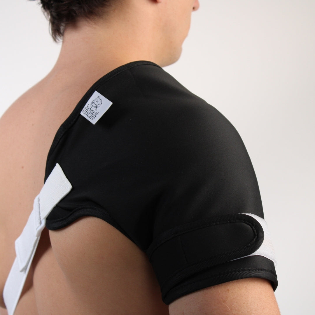 Person wearing castor oil shoulder wrap white accents on a plain background - part of the castor oil shoulder pack