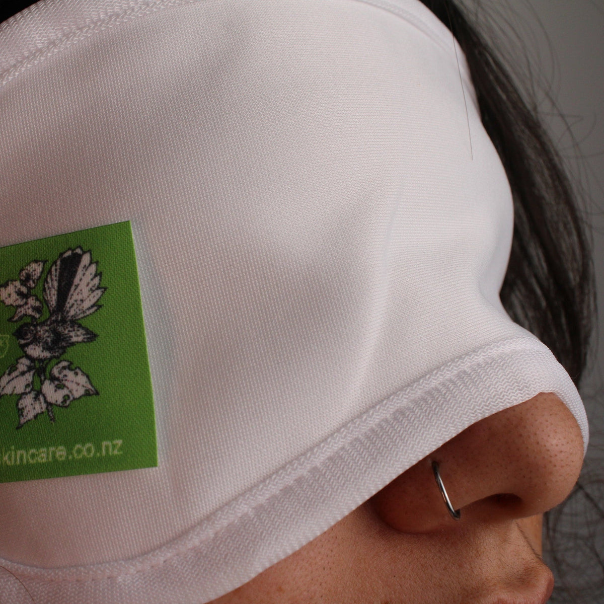 Close-up of a person wearing a castor oil pack eye mask for relaxation and wellness.