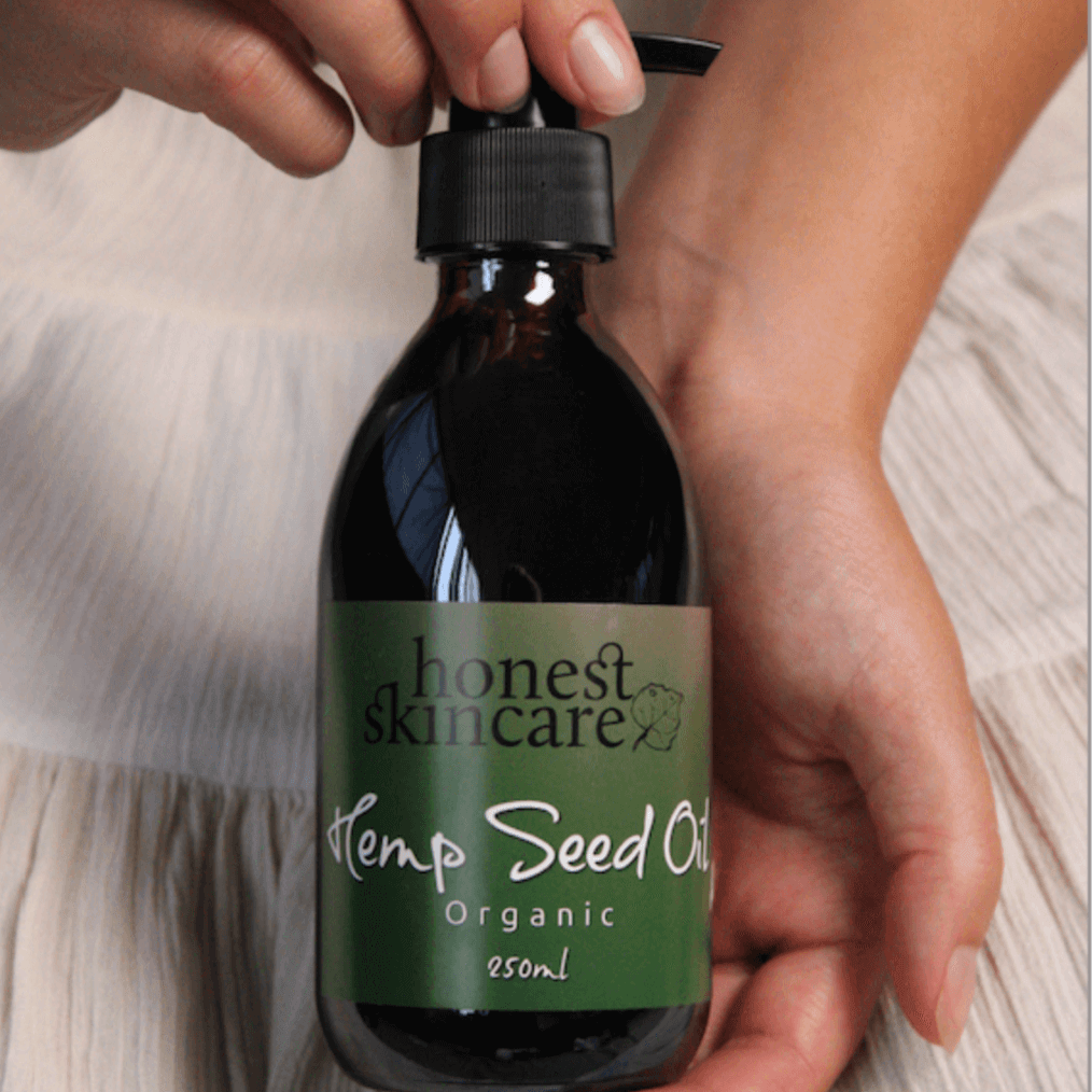 Cold pressed hemp seed oil in a 250ml bottle held by a person with a light background.