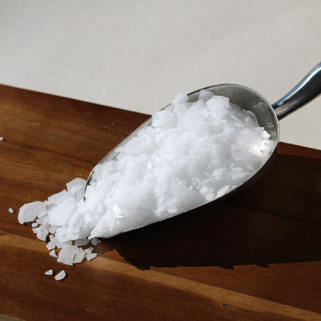 Magnesium for muscle recovery in bulk, showcased in a metal scoop on a wooden surface.