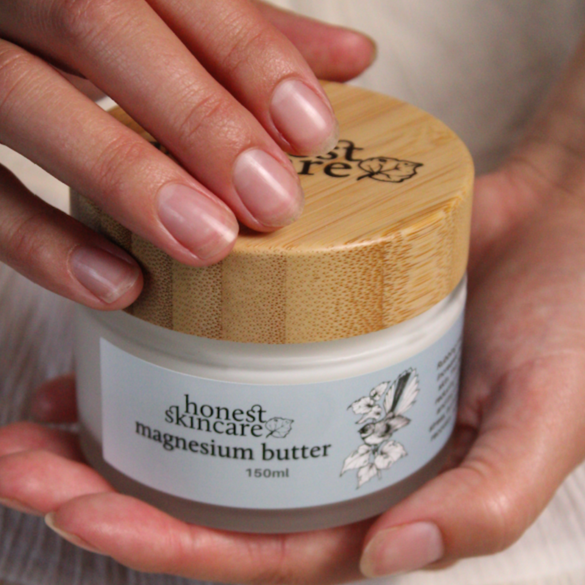 Hand holding a jar of magnesium butter by Honest Skincare, promoting magnesium for muscle recovery and relaxation.