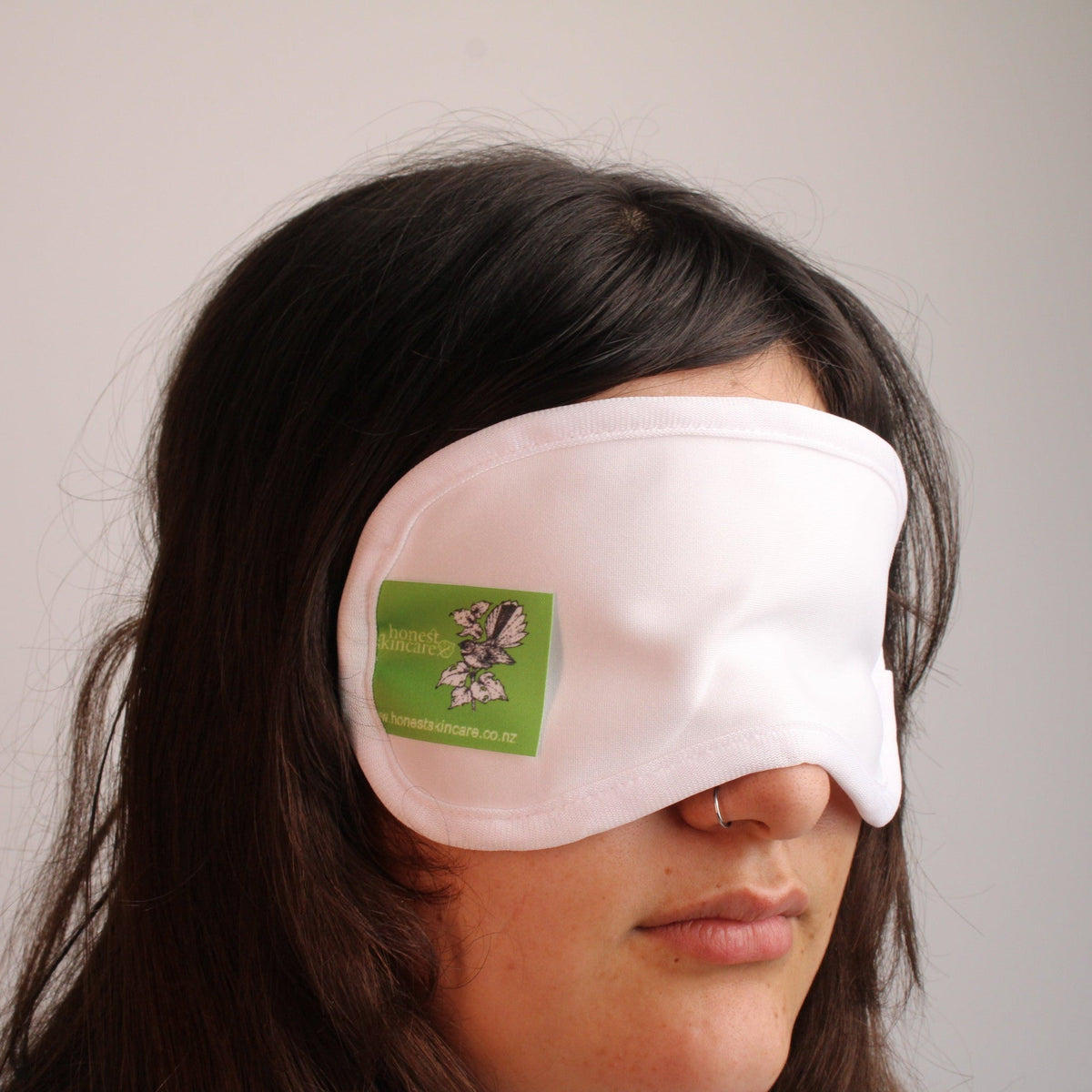Woman wearing a soft sleep mask for better sleep, also great for wearing with hair growth oils for lashes and brows