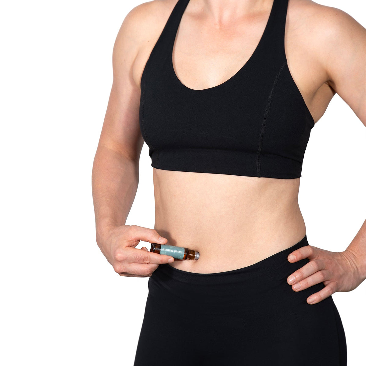 Woman applying organic castor oil mini roller to her navel for easy absorption